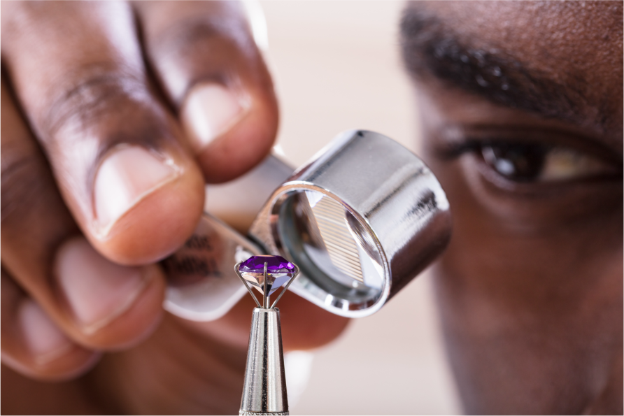 jeweler looking at diamond through diamond loupe tool